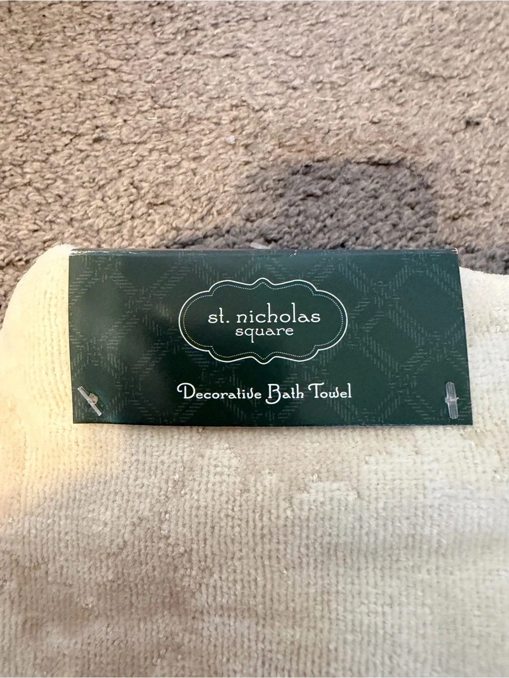 St. Nicholas Square cream holiday towel with red bow and pinecone appliqué
